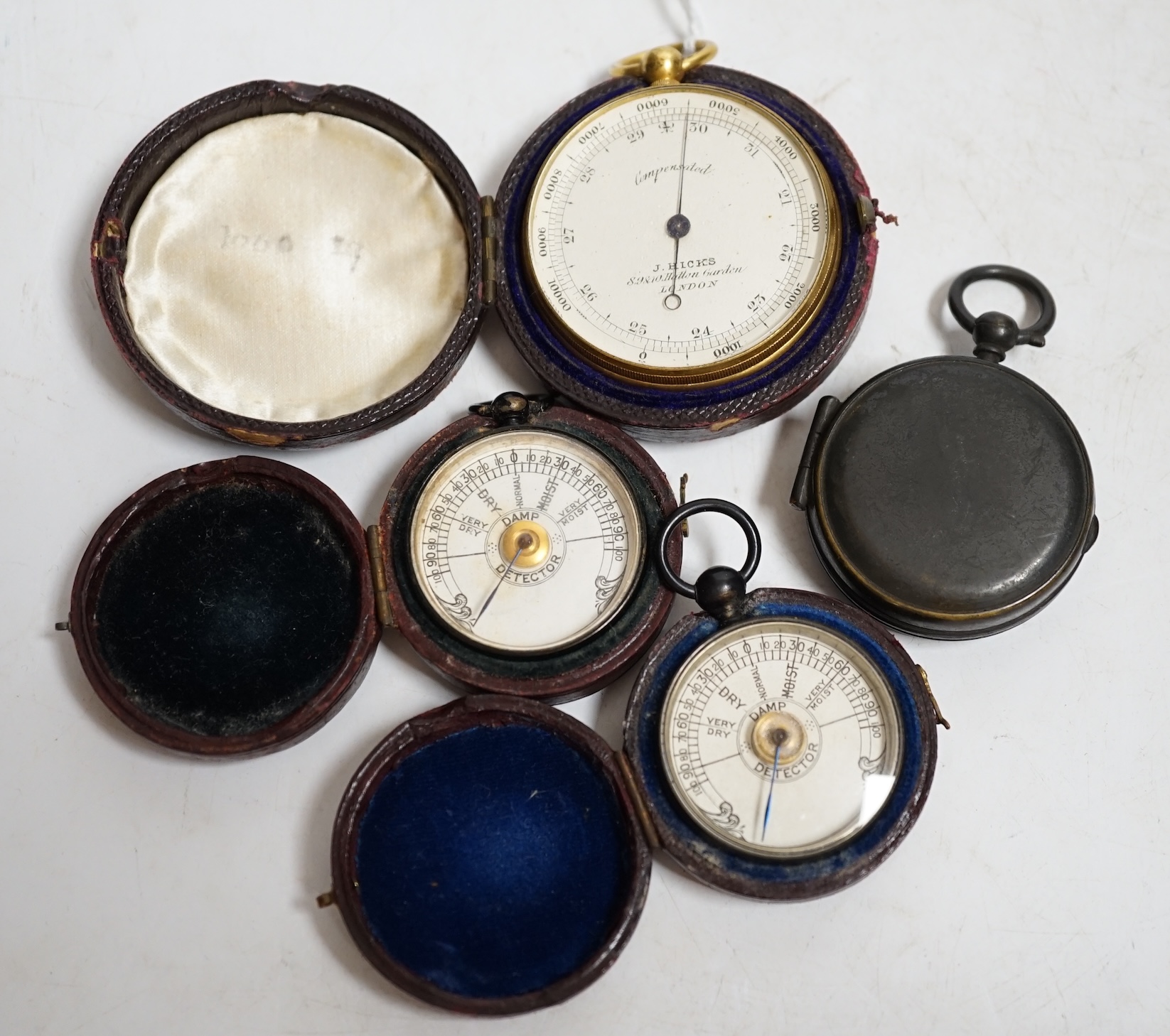 Two pocket damp detectors, a pocket barometer, and a compass, three with original leather cases. Condition - fair